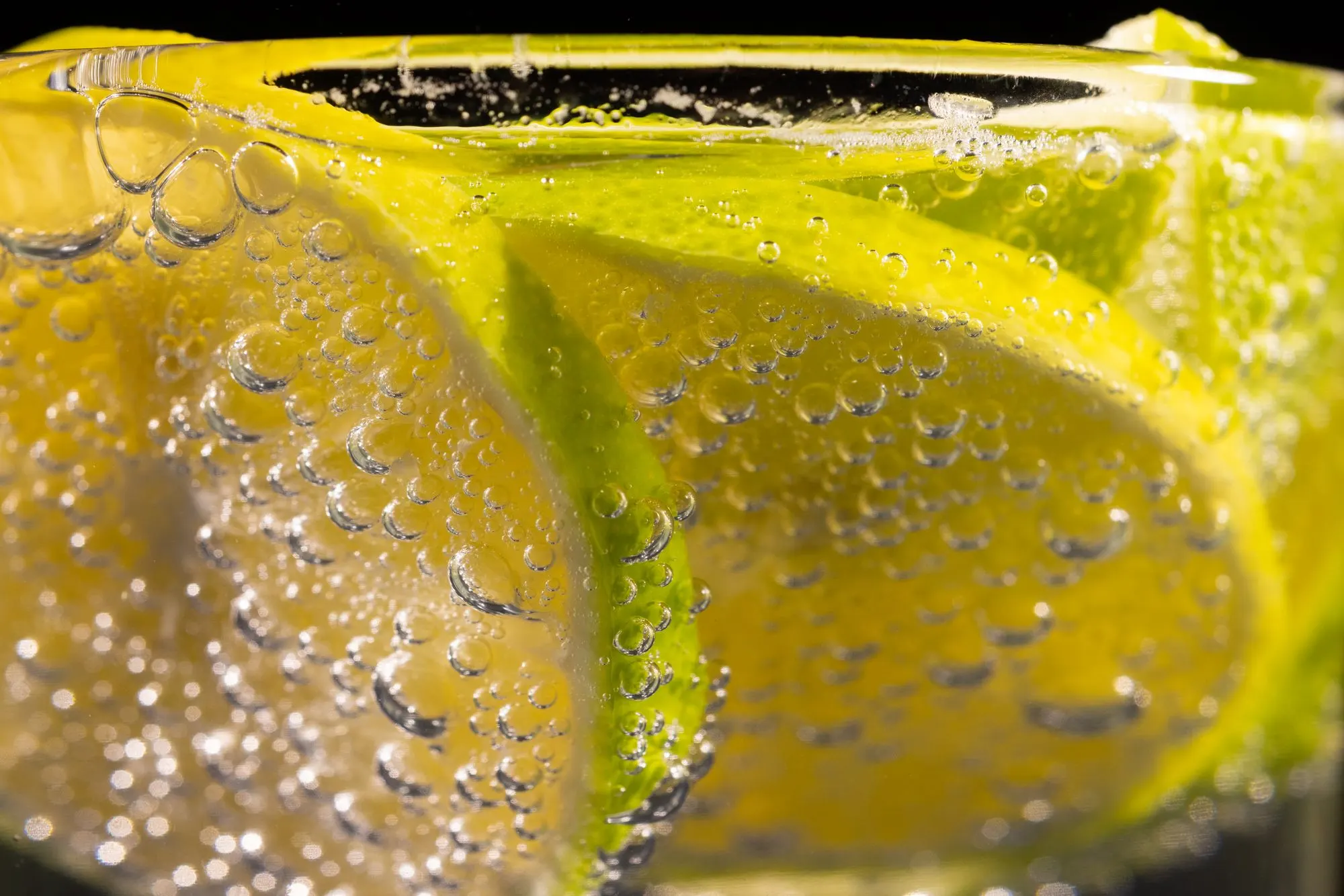 Limon dilimleri arasında yükselen gazoz kabarcıkları